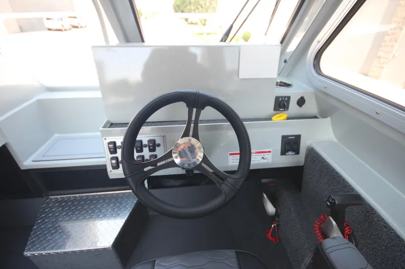 Slide: The Image of Interior of 2026 Weldcraft 220 Ocean King F250 boat, featuring steering wheel and control panel. - 21
