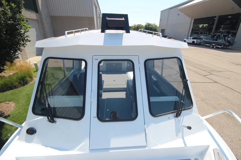 Slide: The Image of 2026 Weldcraft 220 Ocean King F250 boat, front view, docked near a warehouse. - 29