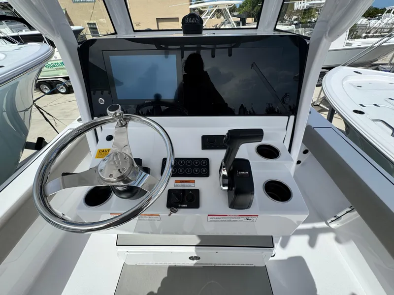 Slide: The Image of 2025 Sportsman Masters 247 Bay Boat helm with steering wheel and control panel. - 21