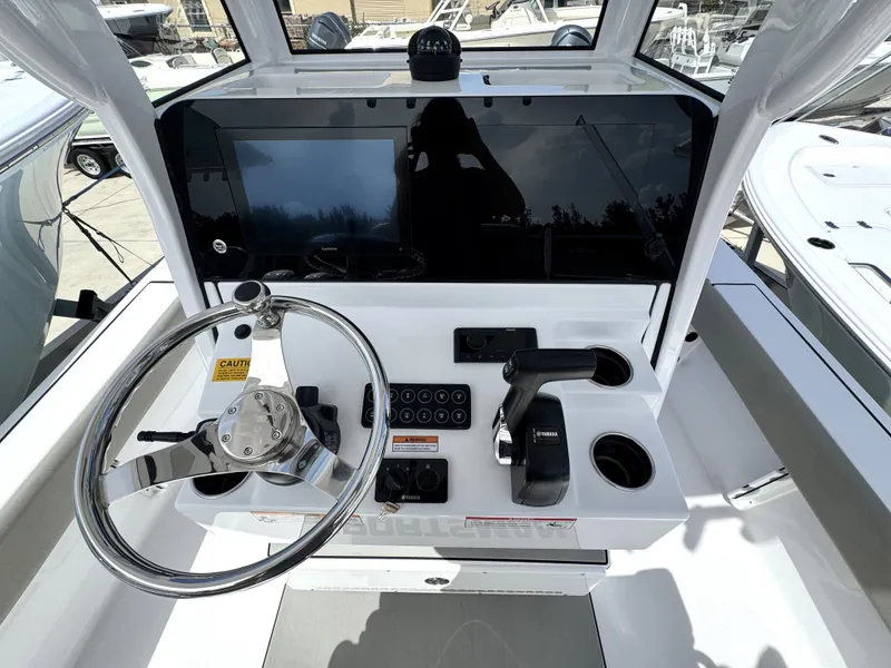 Slide: The Image of 2025 Sportsman Masters 247 Bay Boat helm with steering wheel and control panel. - 22