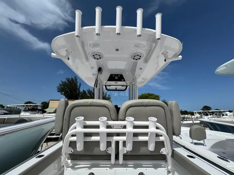 Slide: The Image of 2025 Sportsman Masters 247 Bay Boat with rod holders and seating, under a clear blue sky. - 28