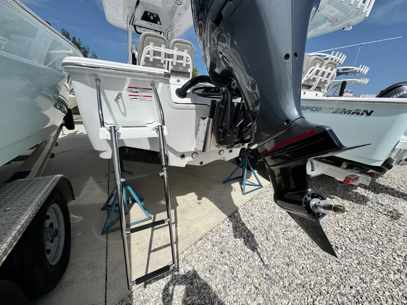 Slide: The Image of 2025 Sportsman Masters 247 Bay Boat with ladder and outboard motor on display. - 6