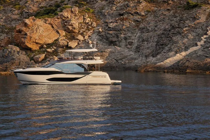 Slide: The Image of Luxury yacht Prestige F5.7 (2026) cruising near rocky coastline at sunset. - 5