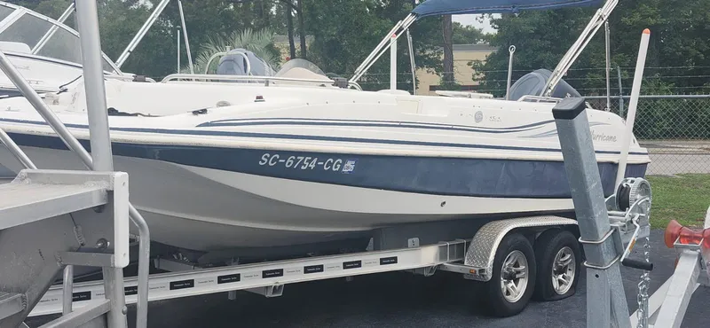 Slide: The Image of 2013 Hurricane SunDeck Sport 201 OB boat on trailer, white and blue design, parked outdoors. - 3