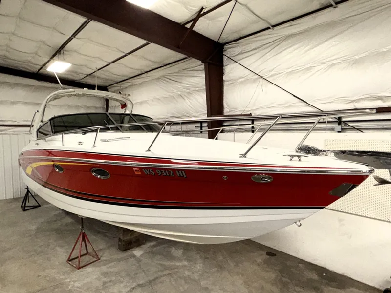 Slide: The Image of 2008 Formula 330 Sun Sport boat in storage, featuring a sleek red and white design. - 2