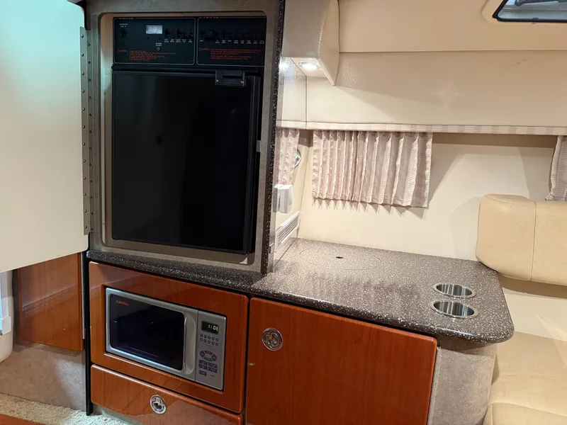 Slide: The Image of 2008 Formula 330 Sun Sport interior with kitchenette, featuring microwave and compact fridge. - 27