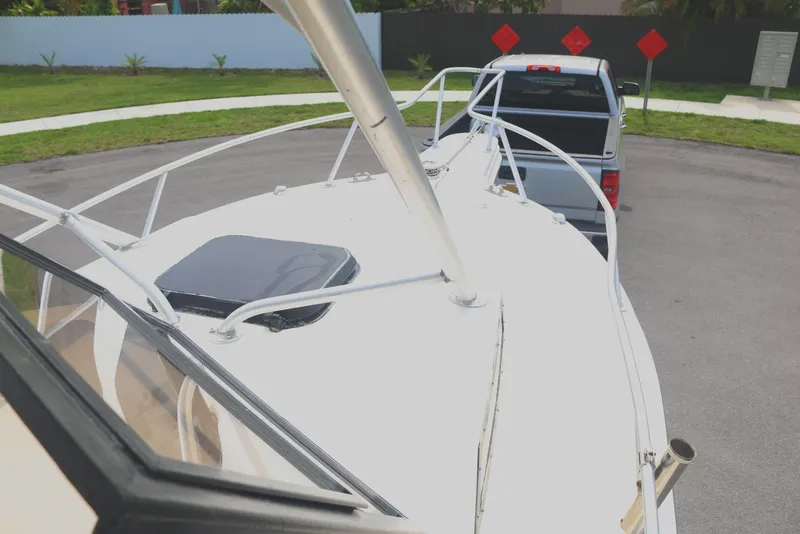 Slide: The Image of 1990 Mako 230 Walk Around boat on trailer, hitched to a truck, parked on a street. - 11