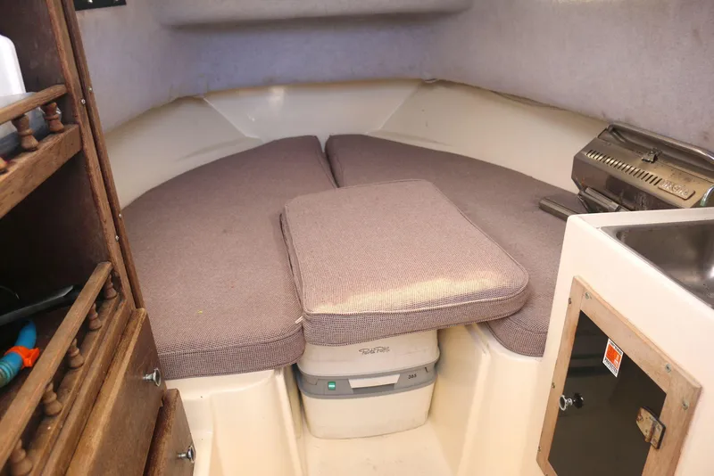 Slide: The Image of 1990 Mako 230 Walk Around cabin interior with cushioned seating and compact amenities. - 14