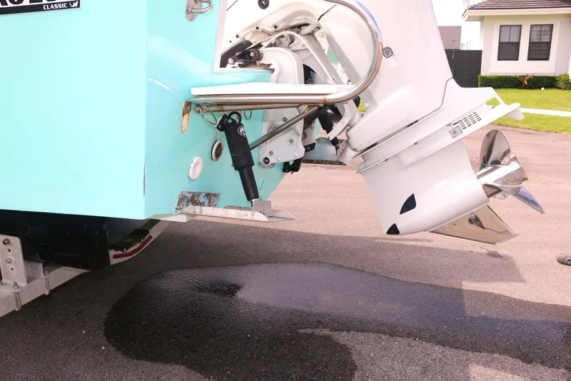 Slide: The Image of 1990 Mako 230 Walk Around boat with outboard motor on pavement. - 17