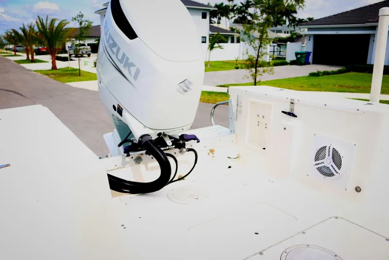 Slide: The Image of 1990 Mako 230 Walk Around boat with Suzuki outboard motor, parked in a suburban neighborhood. - 5