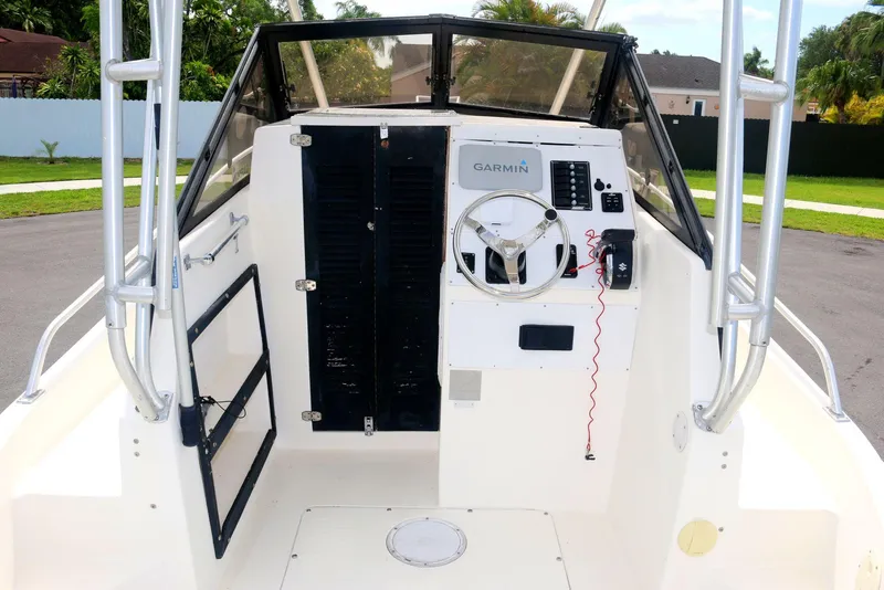 Slide: The Image of 1990 Mako 230 Walk Around boat interior with steering wheel and control panel. - 9