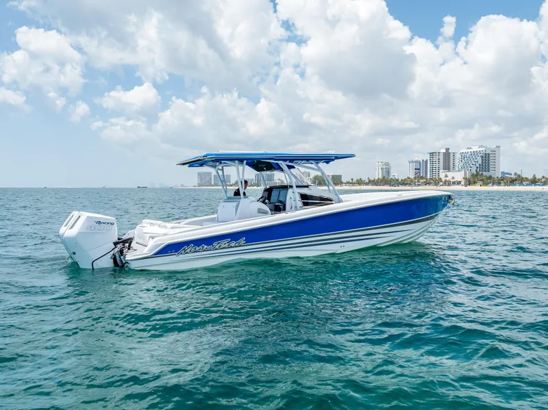 The Image of 2025 Nor-Tech 340 Sport boat on open water, blue and white design, clear sky background. - 0