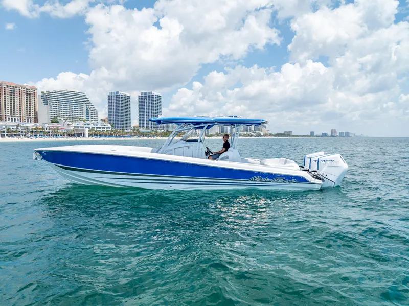 Slide: The Image of 2025 Nor-Tech 340 Sport boat cruising near a city skyline on a sunny day. - 1