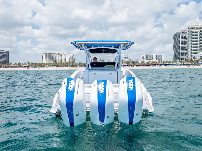 Slide: The Image of 2025 Nor-Tech 340 Sport boat with triple engines on open water, city skyline in background. - 11