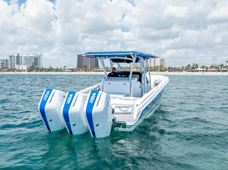 Slide: The Image of 2025 Nor-Tech 340 Sport boat with triple outboard engines on open water. - 12