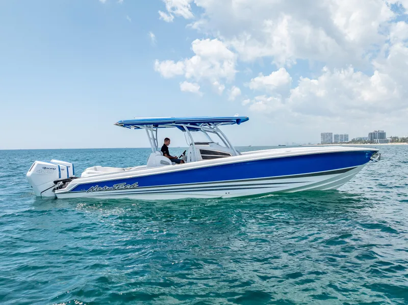 Slide: The Image of 2025 Nor-Tech 340 Sport boat on open water, featuring sleek blue and white design. - 13