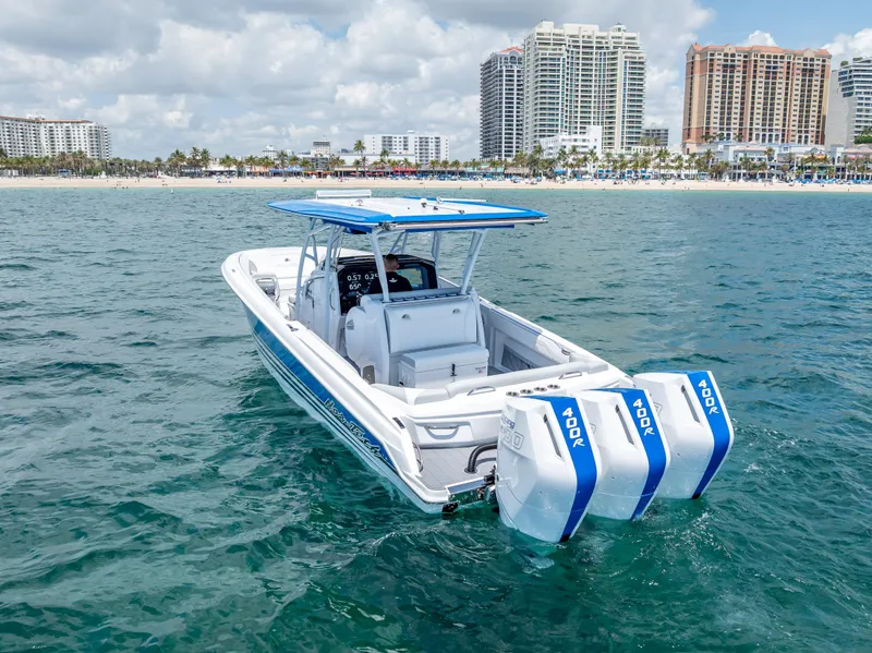 Slide: The Image of 2025 Nor-Tech 340 Sport boat with triple engines on ocean near city skyline. - 2