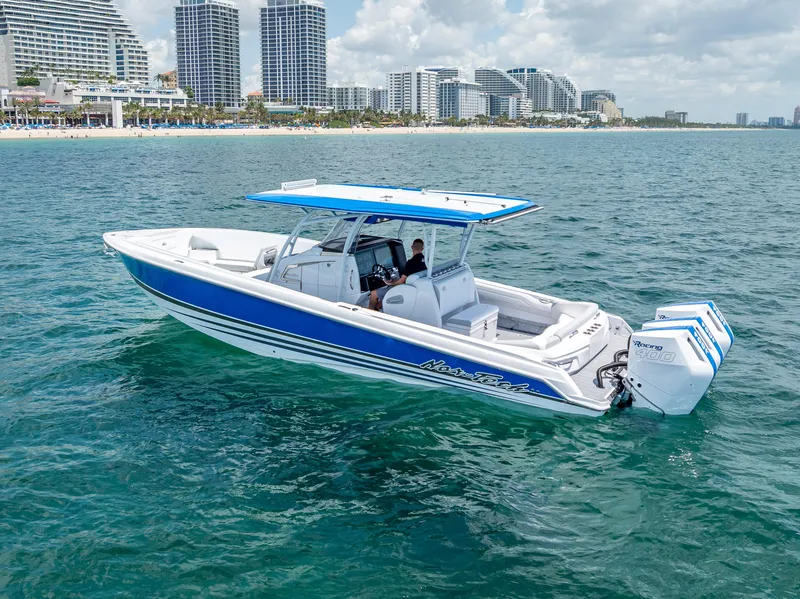 Slide: The Image of 2025 Nor-Tech 340 Sport boat cruising near a city skyline on a sunny day. - 20