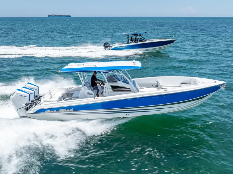 Slide: The Image of 2025 Nor-Tech 340 Sport boat cruising on ocean, featuring sleek blue and white design. - 22