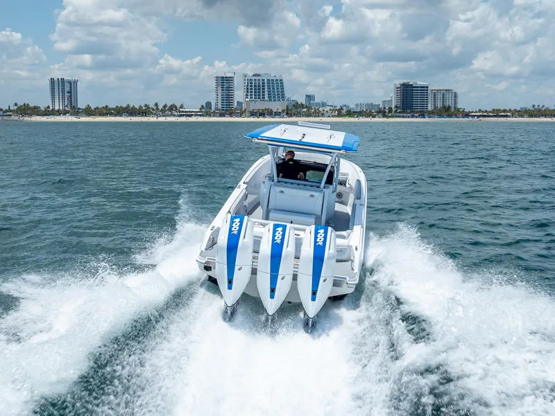 Slide: The Image of 2025 Nor-Tech 340 Sport boat cruising on ocean near city skyline. - 23