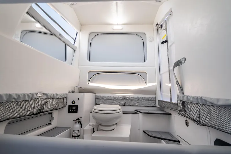 Slide: The Image of Interior of 2025 Nor-Tech 340 Sport boat, featuring a modern bathroom with sleek design. - 26