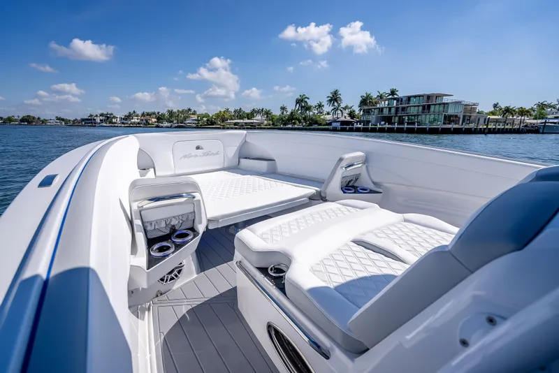 Slide: The Image of 2025 Nor-Tech 340 Sport boat interior with luxurious seating, on a sunny day by the water. - 29