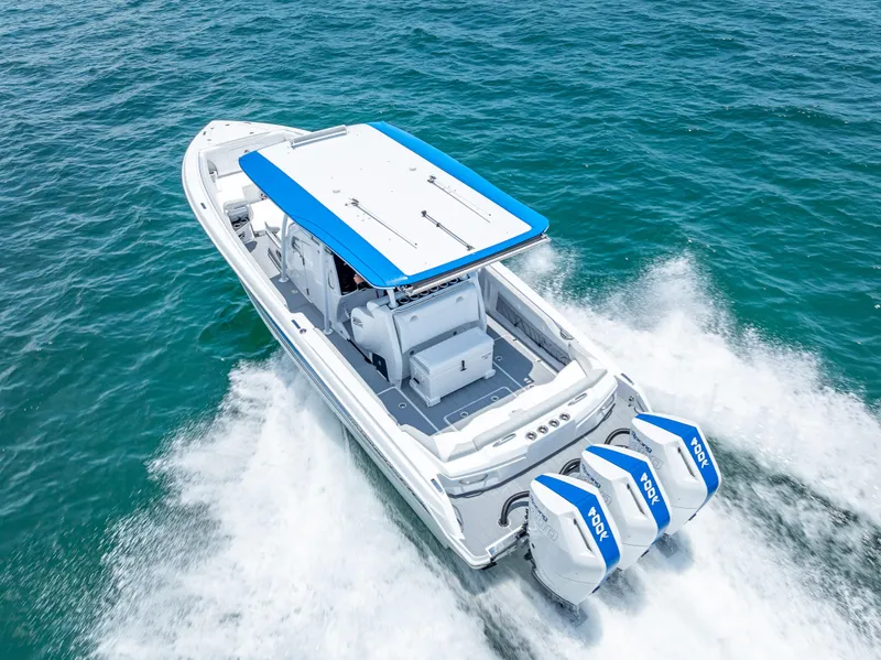 Slide: The Image of 2025 Nor-Tech 340 Sport boat cruising on open water with triple outboard engines. - 3