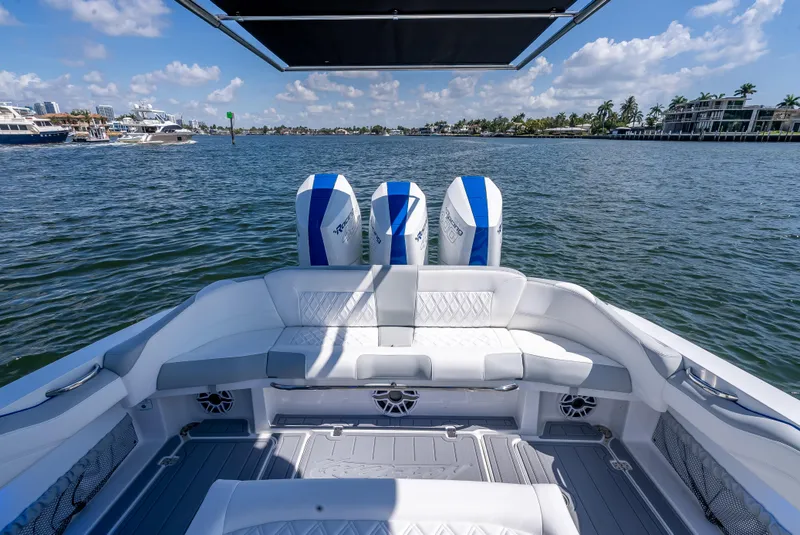 Slide: The Image of 2025 Nor-Tech 340 Sport boat with triple engines, spacious seating, and scenic waterfront view. - 35