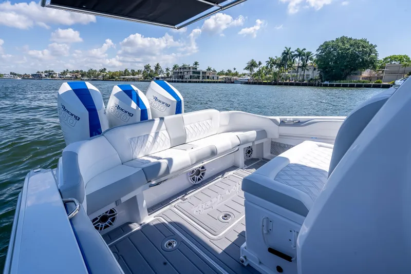 Slide: The Image of 2025 Nor-Tech 340 Sport boat with luxurious seating, triple engines, and scenic waterfront view. - 36