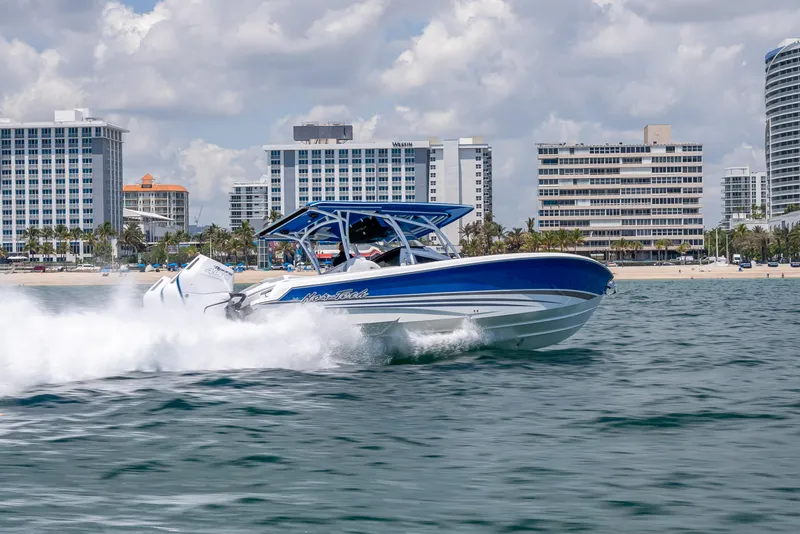 Slide: The Image of 2025 Nor-Tech 340 Sport boat cruising near city skyline on a sunny day. - 46