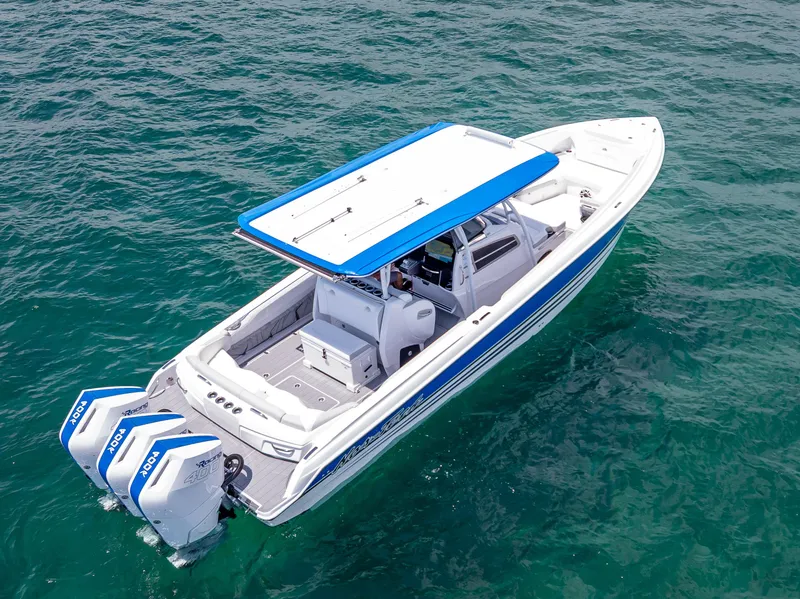 Slide: The Image of 2025 Nor-Tech 340 Sport boat on clear blue water, featuring twin outboard engines. - 47