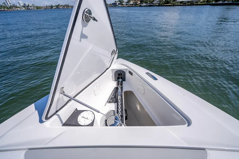 Slide: The Image of 2025 Nor-Tech 340 Sport boat anchor compartment open on calm water. - 6