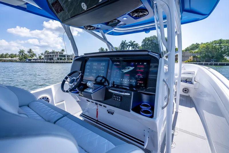 Slide: The Image of 2025 Nor-Tech 340 Sport boat cockpit with advanced navigation system, luxurious seating, and scenic water view. - 8