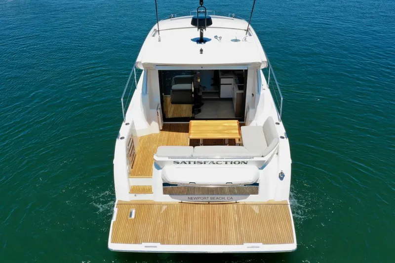 Slide: The Image of 2020 Prestige 460S yacht on water, rear view, featuring spacious deck and seating area. - 11