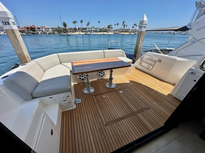 Slide: The Image of Prestige 460S 2020 yacht deck with seating and table, overlooking marina and waterfront homes. - 38