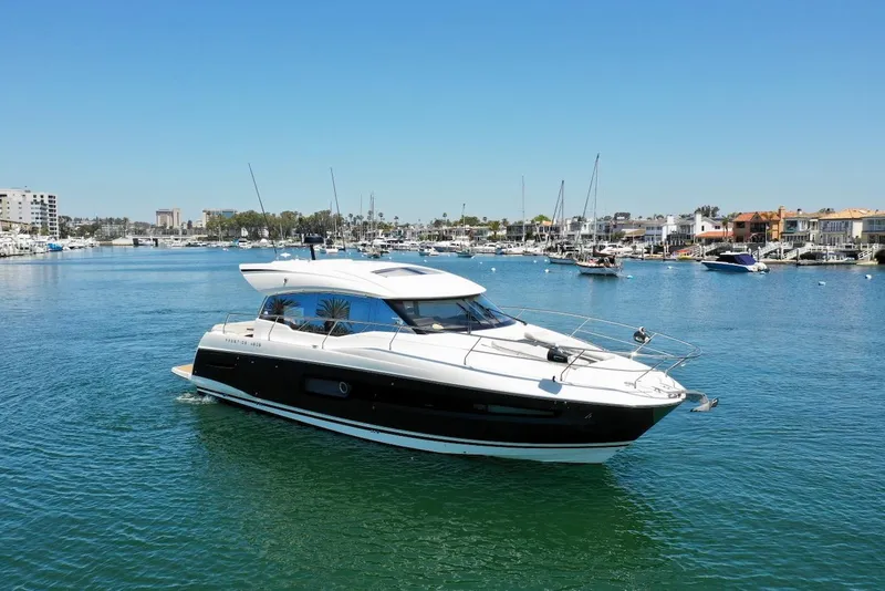 Slide: The Image of 2020 Prestige 460S yacht cruising in a sunny marina, surrounded by boats and waterfront homes. - 39