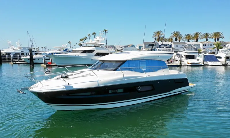 Slide: The Image of 2020 Prestige 460S yacht docked in a marina with palm trees and clear skies. - 8
