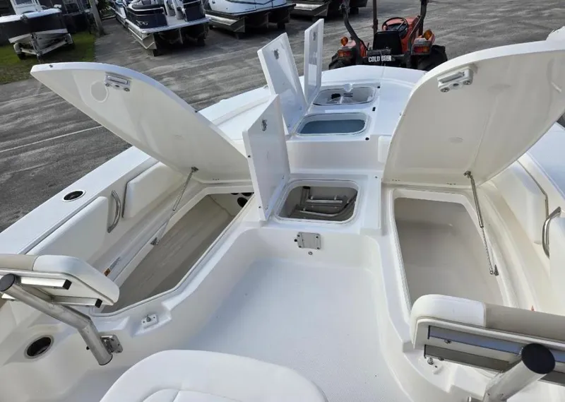 Slide: The Image of 2024 Robalo 246 Cayman boat with open storage compartments and seating area. - 11