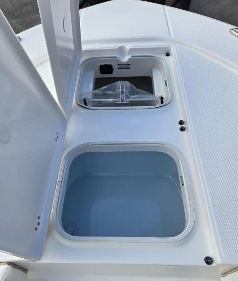 Slide: The Image of 2024 Robalo 246 Cayman boat storage compartments with open lids. - 14