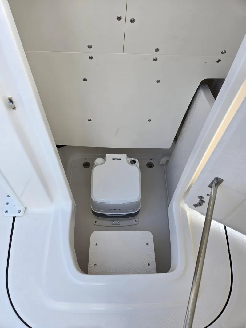 Slide: The Image of 2024 Robalo 246 Cayman boat interior with compact marine toilet. - 17