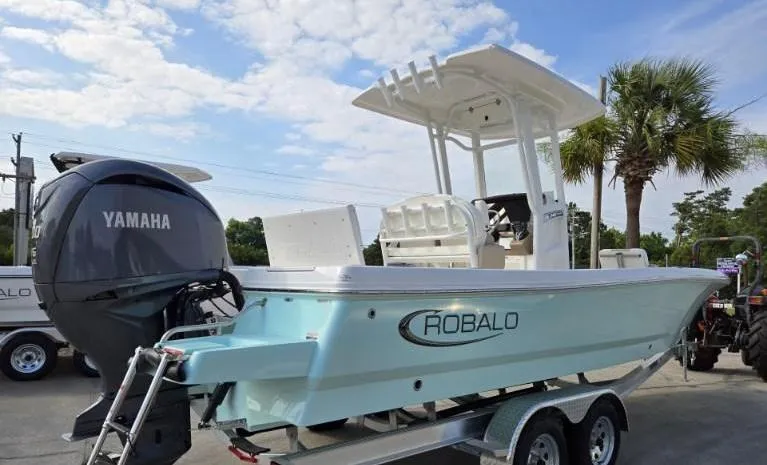 Slide: The Image of 2024 Robalo 246 Cayman boat with Yamaha engine on trailer, under blue sky. - 9