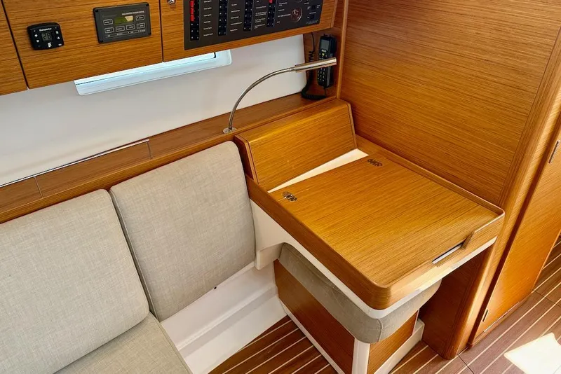 Slide: The Image of 2016 X-Yachts Xp38 interior with wooden navigation station and beige seating. - 35