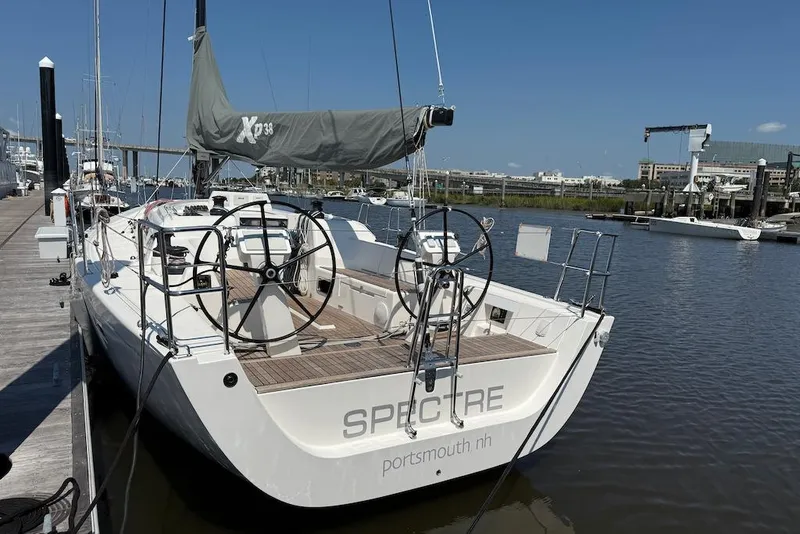Slide: The Image of 2016 X-Yachts Xp38 sailboat docked in a marina, featuring dual steering wheels. - 4