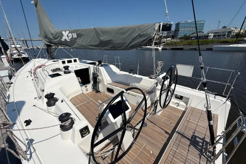 Slide: The Image of 2016 X-Yachts Xp38 sailboat with dual steering wheels, docked in a marina. - 8