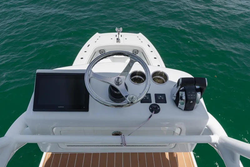 Slide: The Image of Freeman 43 boat helm with steering wheel and controls, 2022 model, on open water. - 26