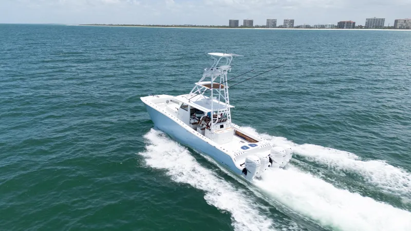 Slide: The Image of 2022 Freeman 43 boat cruising on open water with city skyline in background. - 6