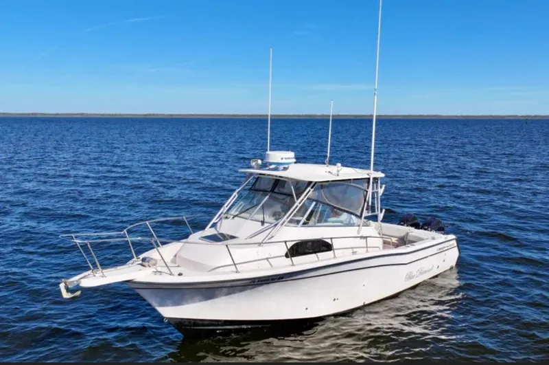 Slide: The Image of 2003 Grady-White Marlin 300 boat on open water under clear blue sky. - 1