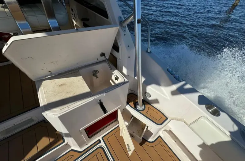 Slide: The Image of 2003 Grady-White Marlin 300 boat interior with open storage compartment, near water. - 19