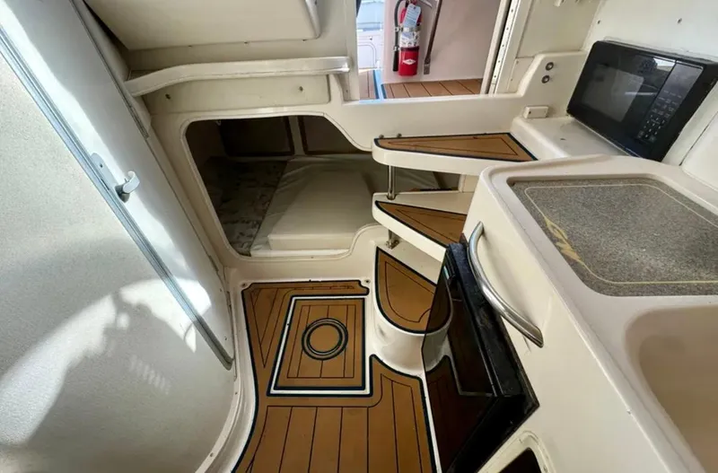 Slide: The Image of 2003 Grady-White Marlin 300 cabin interior with wood flooring, kitchenette, and compact design. - 30