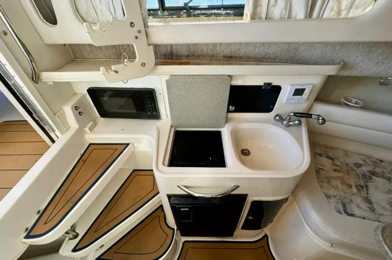 Slide: The Image of 2003 Grady-White Marlin 300 boat interior with kitchenette, sink, and microwave. - 32